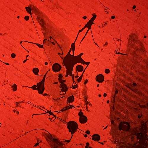 splattered photo emulsion splattered on cardboard lit by red light