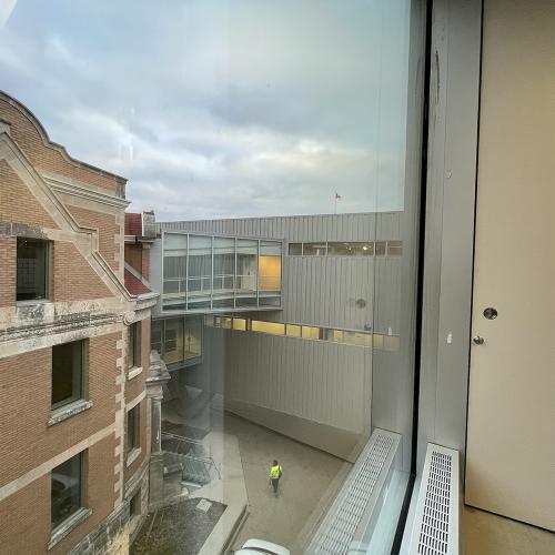 looking out a window at buildings, man walking at ground level