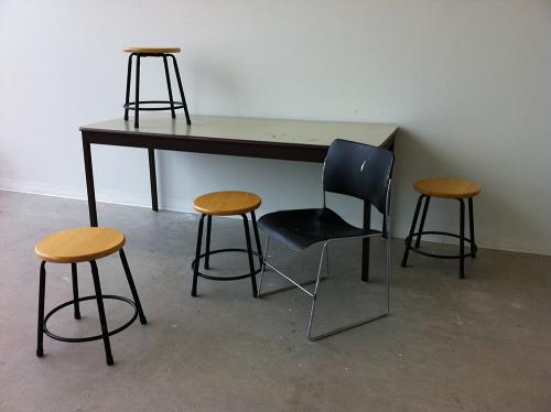 one table and four scattered stools and one black chair